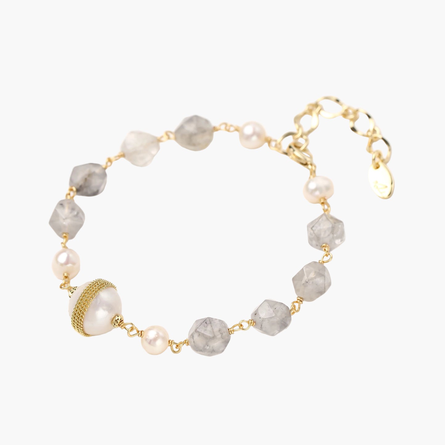 Bracelet with cloudy quartz beads, freshwater pearls, and gold-wrapped baroque pearl centerpiece on white background.