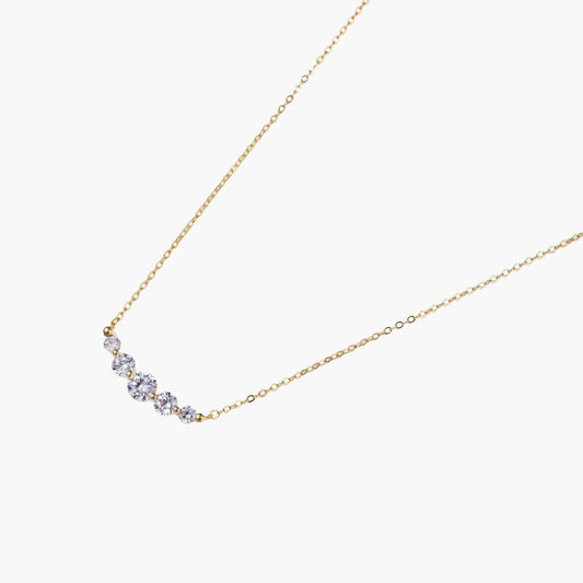 Delicate 14K gold-plated necklace with five graduated zirconia stones arranged in a curved arc on fine chain